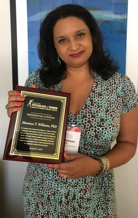 Dr. Monnica Williams holding an award.