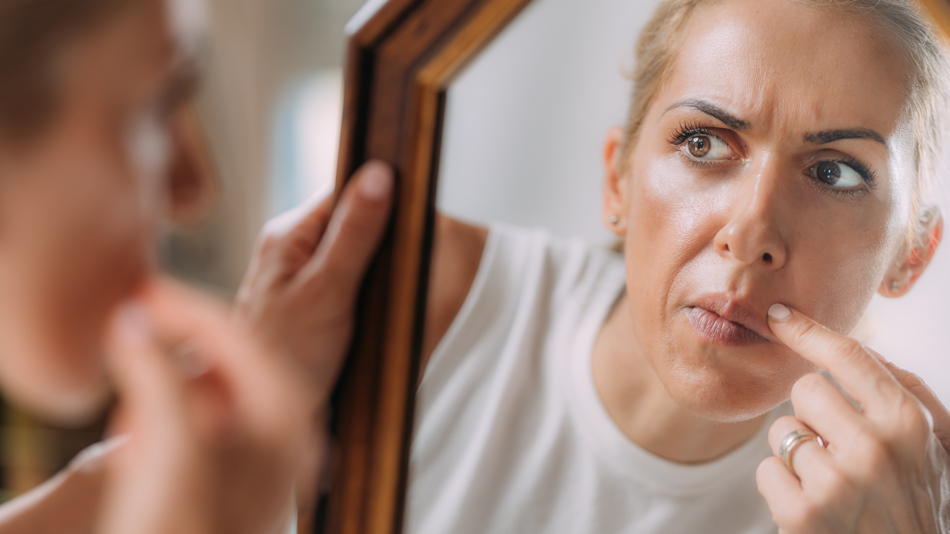 Anxious woman looking in the mirror